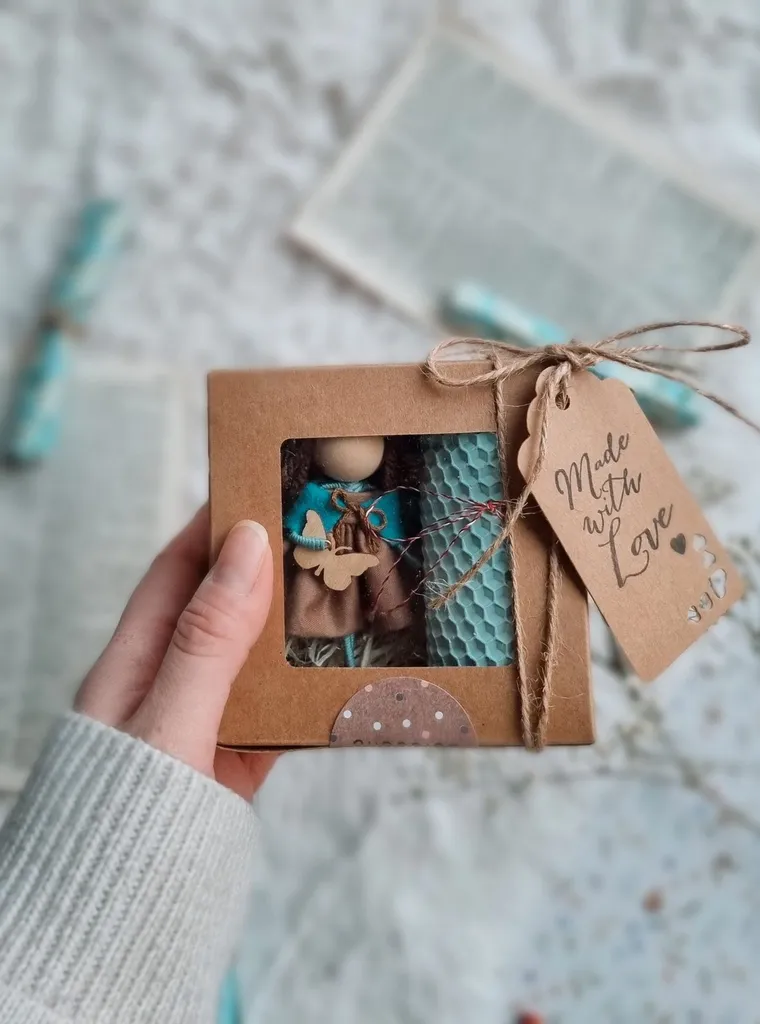 Hand holding a small gift box tagged 'Made with love'