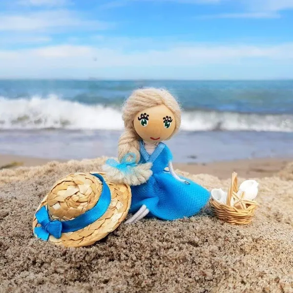 Doll in a blue dress on the beach