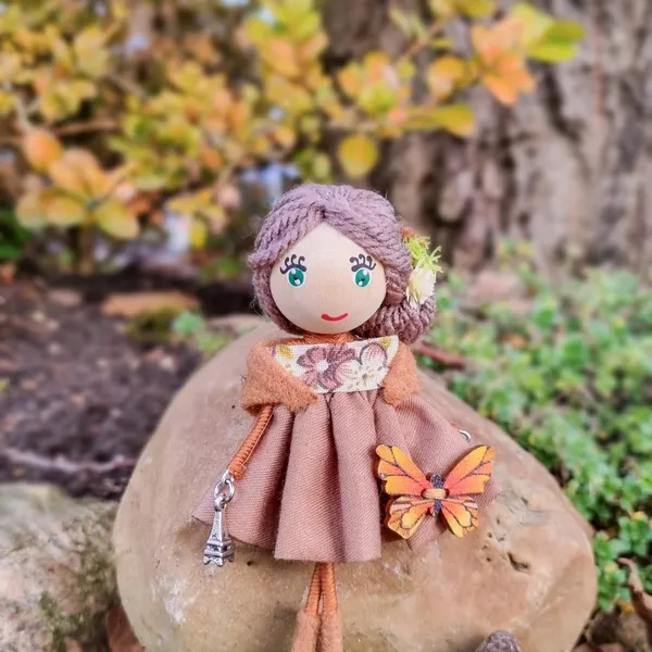Autumn doll with a butterfly on a rock