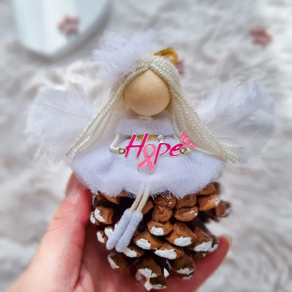 'Hope' angel doll on a pine cone