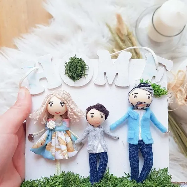 Family dolls in a 'Home' frame