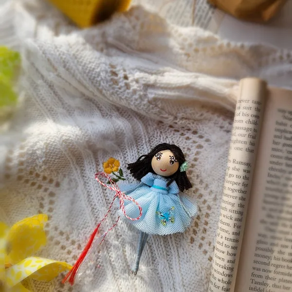 Doll in a turquoise dress on white lace