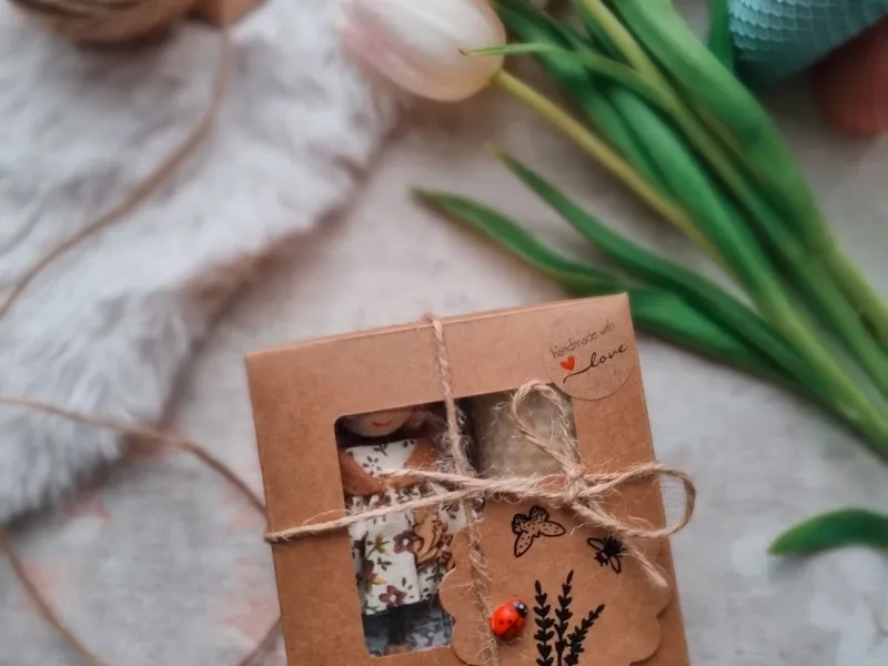 Gift box tied with twine next to tulips