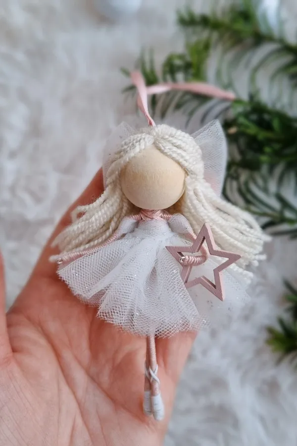 Christmas angel doll with a star, held in a hand