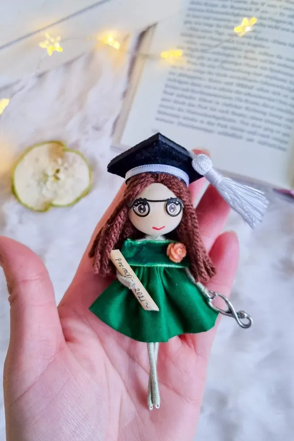 Graduation doll with cap and diploma in a green dress